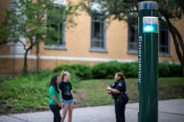 A UNT police officer chats with students