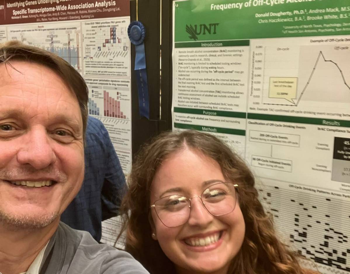 two researchers in front of research poster